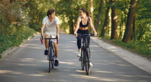 a man and woman riding bicycles on a road