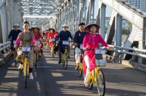 a group of people riding bicycles on a bridge