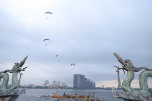 a group of people in a boat with a dragon and a dragon statue